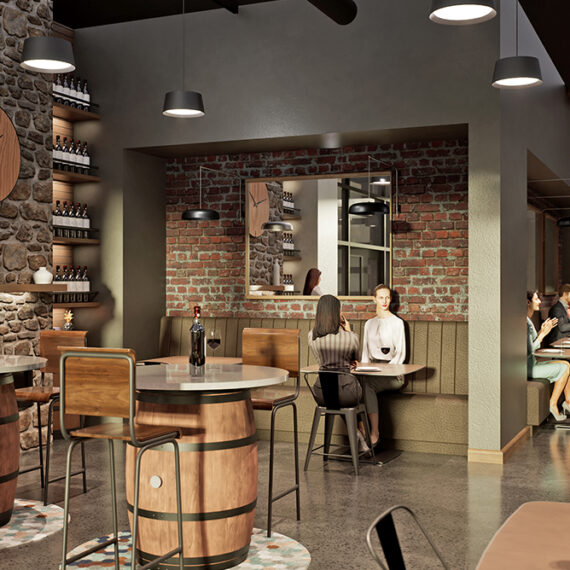 People sit and drink wine and talk in a cozy boutique wine bar. Wine bottles line the wall. Exposed brick and industrial style finishings create a rustic look.